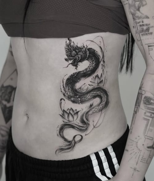 A black and grey Japanese-style dragon with floral elements on the rib, featuring intricate details and smooth shading — by Jian Liang, los angeles