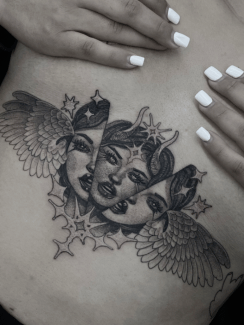 A black and grey surrealistic tattoo on the rib, featuring three faces with wings and star-like elements, showcasing intricate linework and shading — by tyler_whitlock, los angeles
