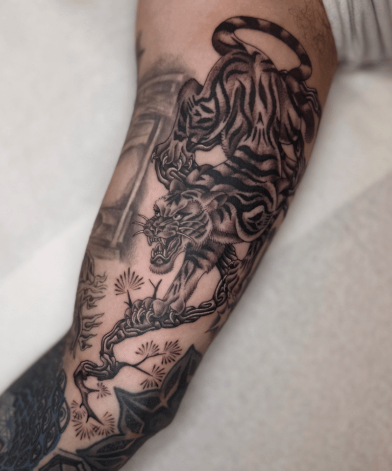 black and grey japanese tiger and snake forearm tattoo with a blossom branch by Engram, a japanese tattoo artist in los angeles