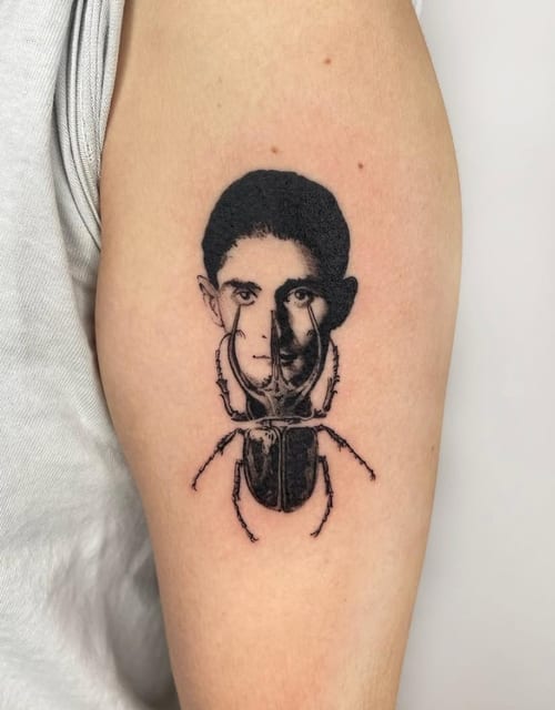 A surreal black and grey tattoo on the upper arm combining a human portrait with an insect body, featuring bold black lines and shading — by Level tattoo, los angeles