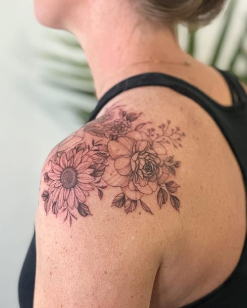 A delicate black and grey floral bouquet tattoo on the shoulder, featuring fine line work and clean detailing — by Melanie Benoit, los angeles