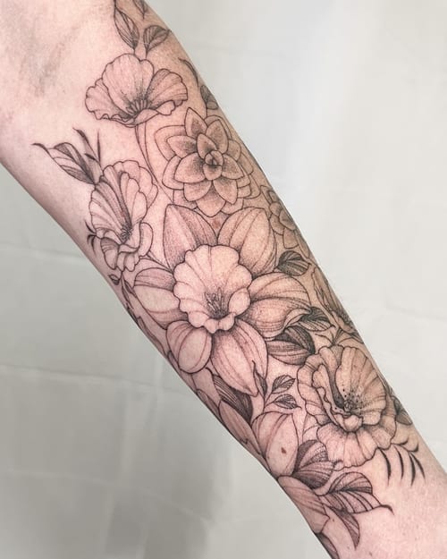 A delicate black and grey floral arrangement tattoo on the forearm, featuring fine line work and intricate details — by Melanie Benoit, los angeles