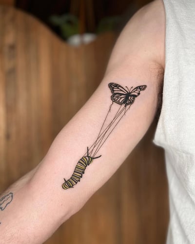 A delicate fine line tattoo of a butterfly and caterpillar on the inner arm, featuring minimalistic design with mixed color and black ink — by Dylan Aiello, los angeles