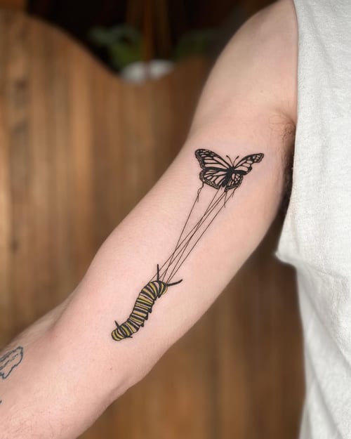 A delicate fine line tattoo of a butterfly and caterpillar on the inner arm, featuring minimalistic design with mixed color and black ink — by Dylan Aiello, los angeles