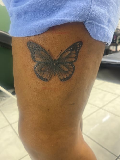 A minimalist black and grey butterfly tattoo on the thigh with clean lines and simple shading — by Mr._Folks, los angeles