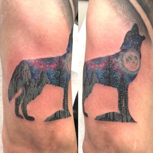 A colorful silhouette of a howling wolf with a landscape scene on the upper arm, featuring a moon and trees — by Sandra Price, los angeles