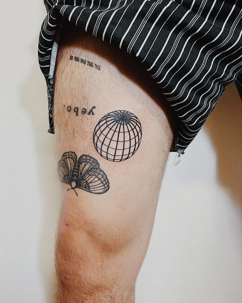 A minimalist black ink tattoo of a butterfly and globe on the thigh, featuring clean linework — by Level tattoo, los angeles