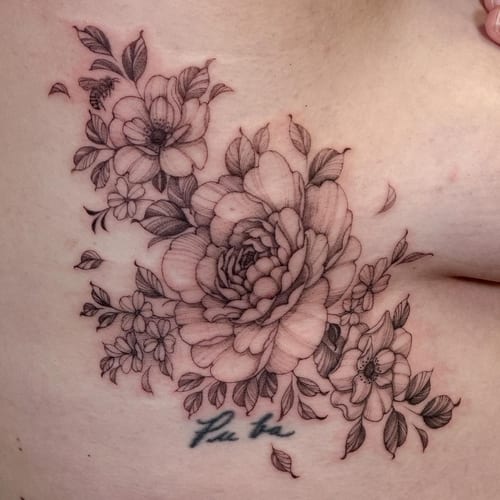 A delicate black and grey floral bouquet tattoo on the rib, featuring fine line work and intricate details — by Melanie Benoit, los angeles