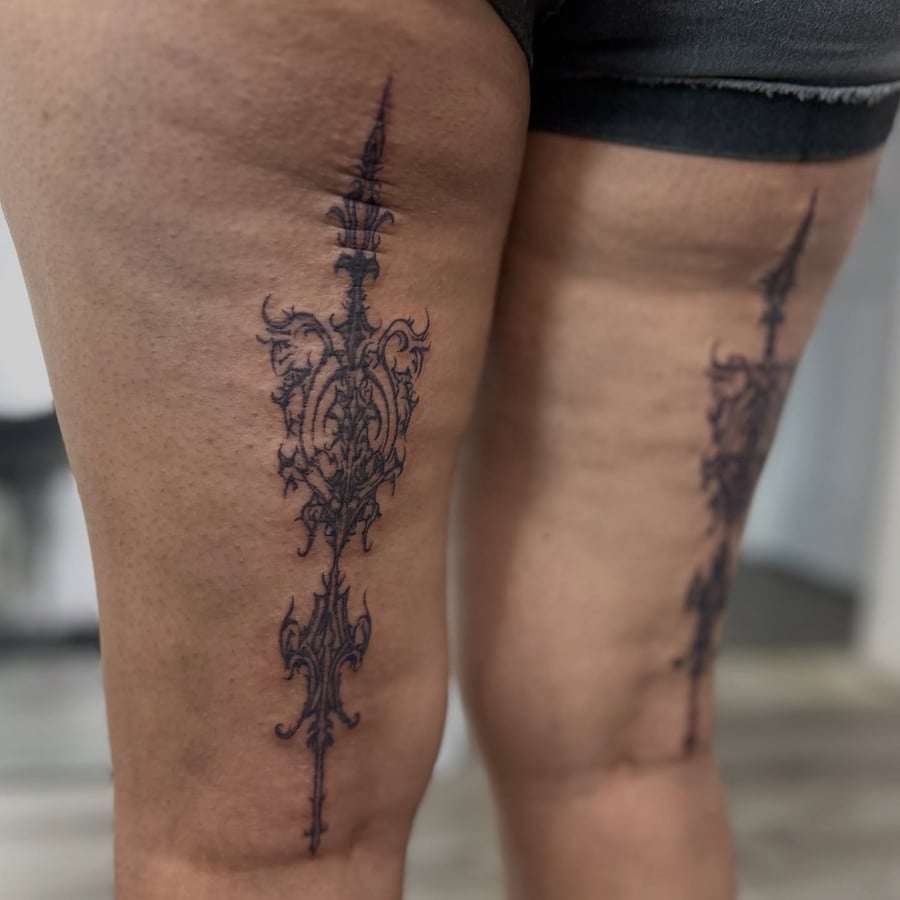 An ornate black and grey ornamental dagger tattoo on the thigh — by Maddie Ramirez, los angeles