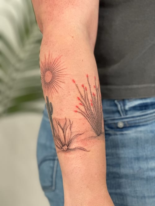 A minimalist fine line tattoo of a desert landscape with a sun and cactus on the forearm, featuring delicate line work and subtle color accents — by Melanie Benoit, los angeles