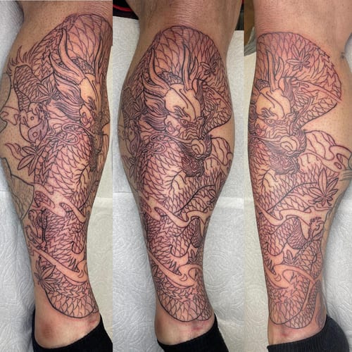 A bold black and grey Japanese dragon tattoo on the calf with intricate linework and detailed scales — by Sandra Price, los angeles