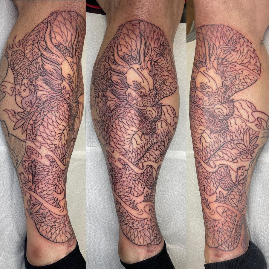 A bold black and grey Japanese dragon tattoo on the calf with intricate linework and detailed scales — by Sandra Price, los angeles