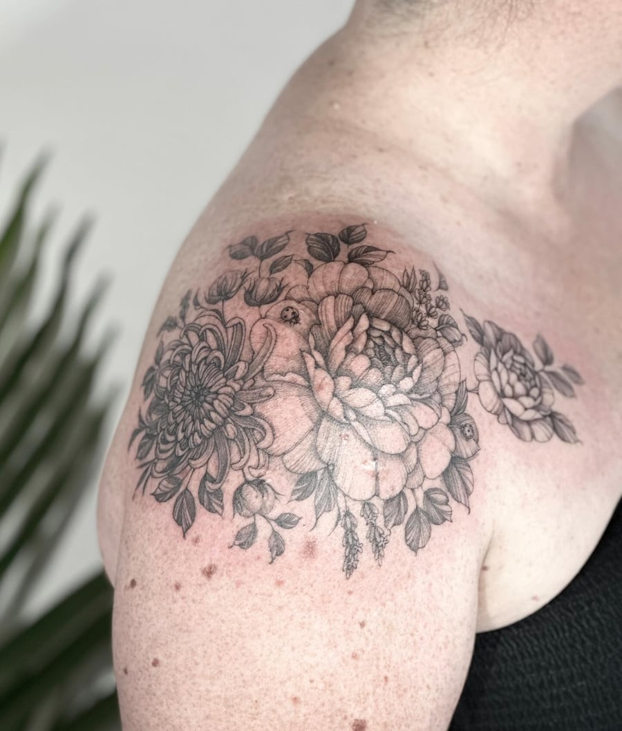 A delicate black and grey floral bouquet tattoo on the shoulder, featuring detailed flowers and leaves — by Melanie Benoit, los angeles
