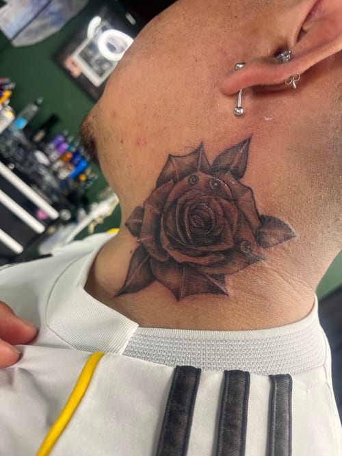 A black and grey realistic rose tattoo on the neck with detailed shading and depth — by Mr._Folks, los angeles