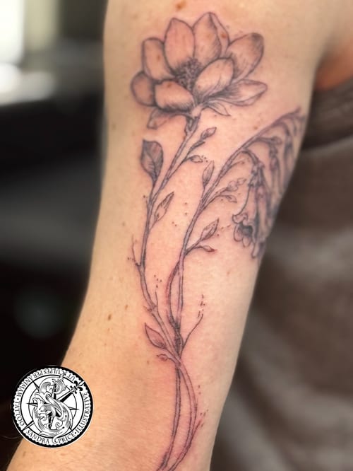 A delicate black and grey fine line flower tattoo on the arm, featuring detailed botanical elements — by Sandra Price, los angeles