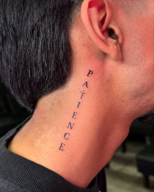 A minimalist black script lettering tattoo on the neck spelling 'patience' vertically — by zealous, los angeles