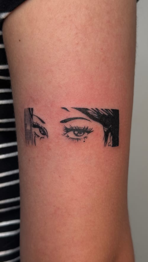A minimalist black and grey tattoo of a pair of eyes with fine linework on the upper arm — by NJ TATTOOZ, los angeles