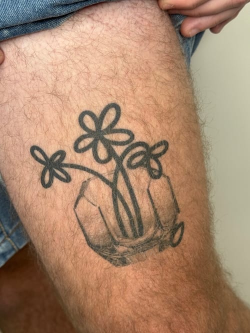 blackwork hand holding flowers tattoo — by Level tattoo, los angeles