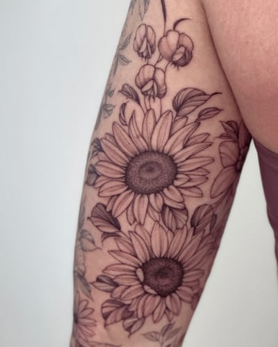 A delicate black and grey sunflower tattoo on the forearm with fine line details and clean shading — by Melanie Benoit, los angeles