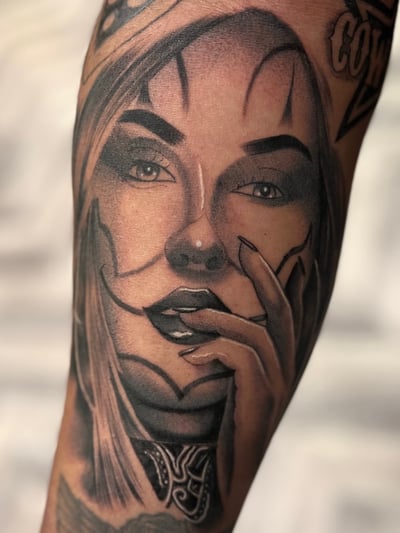 A realistic black and grey portrait of a woman on the forearm, featuring detailed shading and expressive facial features — by Josue Bravo, los angeles