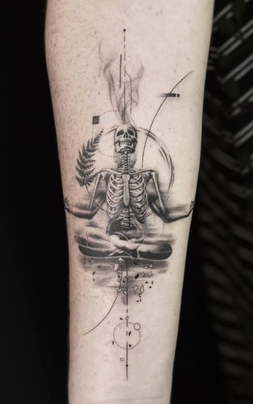 A black and grey tattoo on the forearm featuring a meditative skeleton with geometric and dotwork elements, creating a mystical and abstract design — by Jian Liang, los angeles