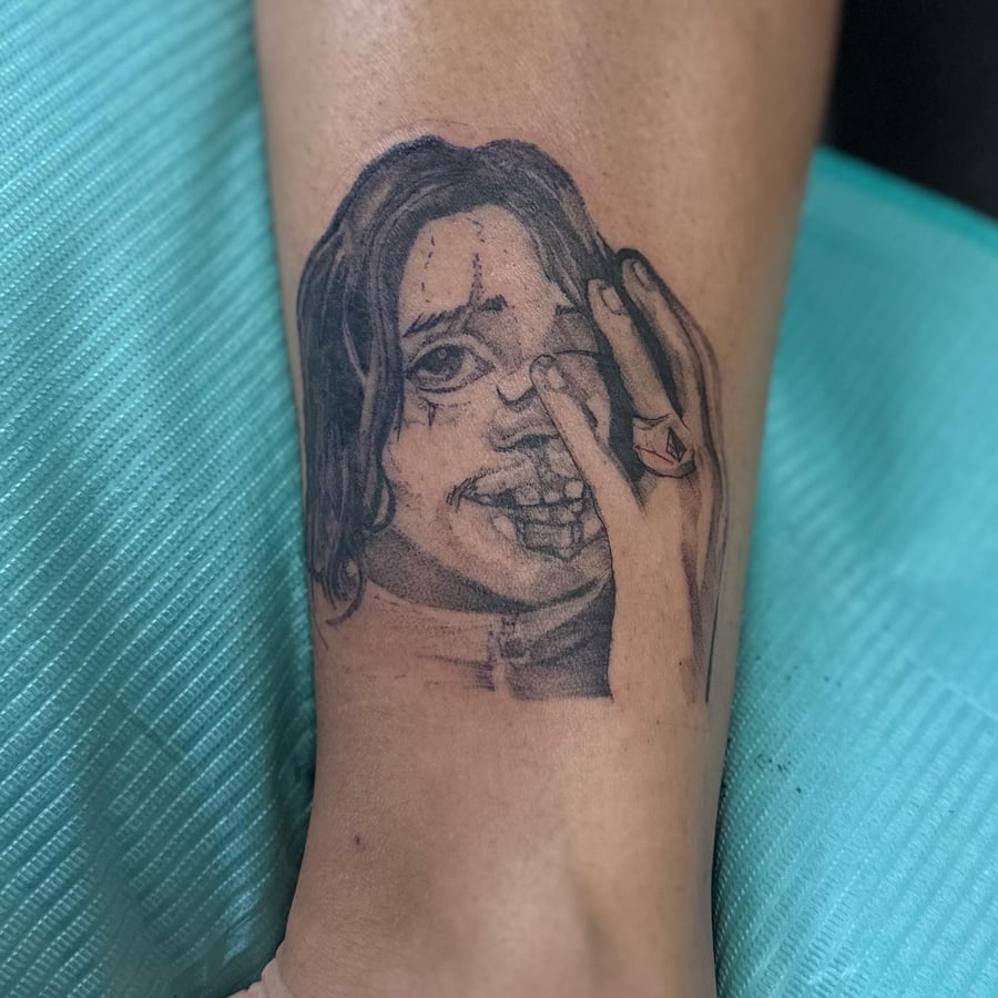 A raw blackwork tattoo of a woman's portrait with a hand on the leg — by Maddie Ramirez, los angeles