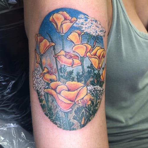 A colorful illustrative tattoo of poppies on the upper arm, featuring delicate floral details and vibrant colors — by Sandra Price, los angeles