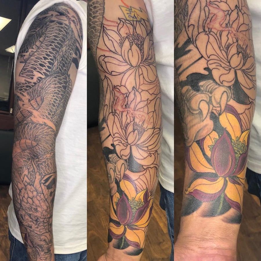 A bold Japanese dragon and flower tattoo sleeve with black and grey shading and colorful floral elements — by Sandra Price, los angeles