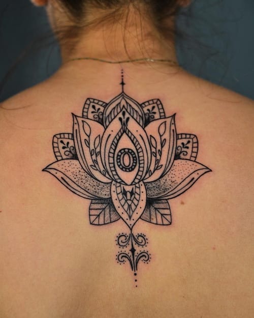 A delicate black and grey ornamental lotus flower tattoo on the back, featuring intricate dotwork and ornate details — by Johnny Ayala, los angeles