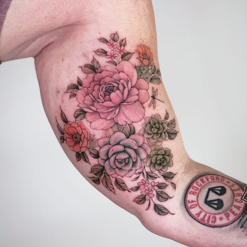 A colorful floral bouquet tattoo on the upper arm with delicate fine line work and romantic details — by Melanie Benoit, los angeles