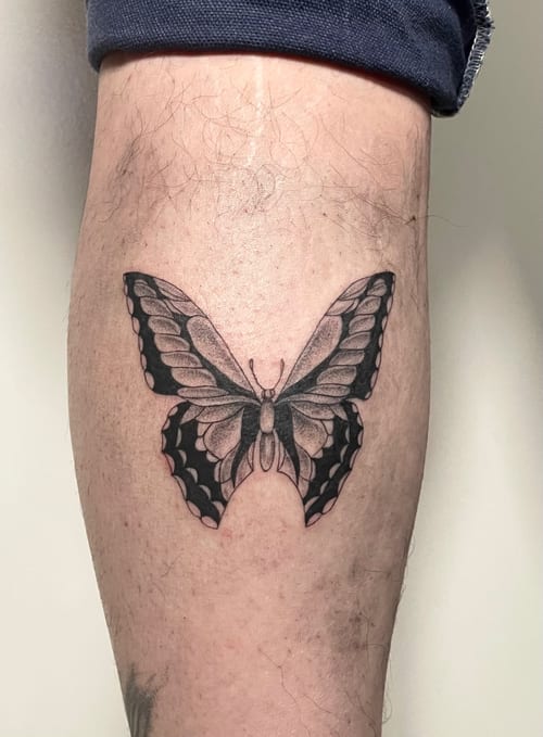 A delicate black and grey butterfly tattoo on the calf with clean illustrative lines — by Brian Kies, los angeles