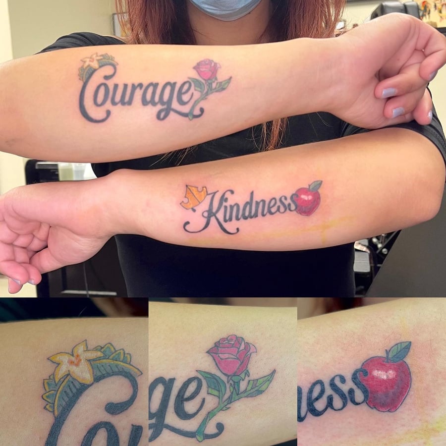A bold and colorful forearm tattoo featuring the words 'Courage' and 'Kindness' with a rose and apple in traditional style — by Sandra Price, los angeles
