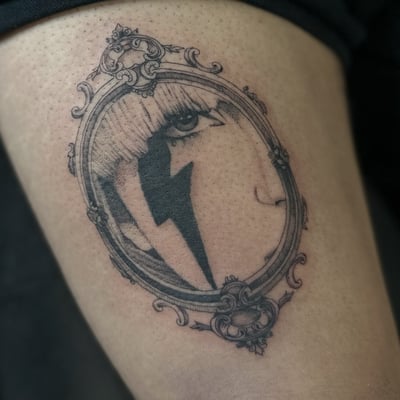 A fine line black and grey portrait tattoo of Lady Gaga in an ornate frame — by Maddie Ramirez, los angeles