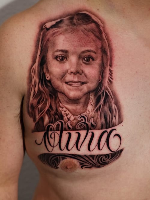 A detailed black and grey portrait of a young girl with her name in script lettering on the chest — by Johnny Ayala, los angeles