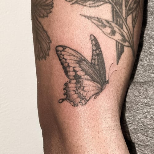A delicate black and grey butterfly tattoo on the forearm with realistic details — by Melanie Benoit, los angeles