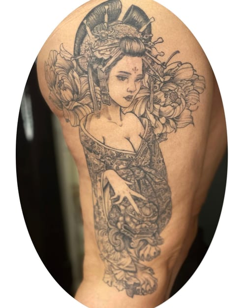 A detailed black and grey geisha portrait on the thigh, featuring ornate floral elements in a Japanese style — by Sandra Price, los angeles