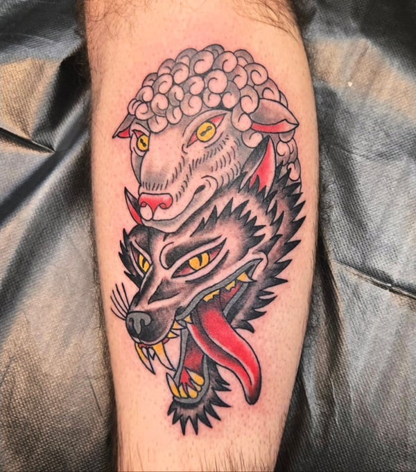 A colorful neo-traditional tattoo on the calf depicting a wolf with a sheep's head, featuring bold lines and vibrant colors — by Dretty, long beach, ca