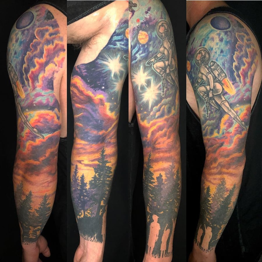 A colorful full sleeve tattoo featuring an astronaut in space with cosmic elements and silhouettes of trees, creating a surreal and bold visual — by Sandra Price, los angeles
