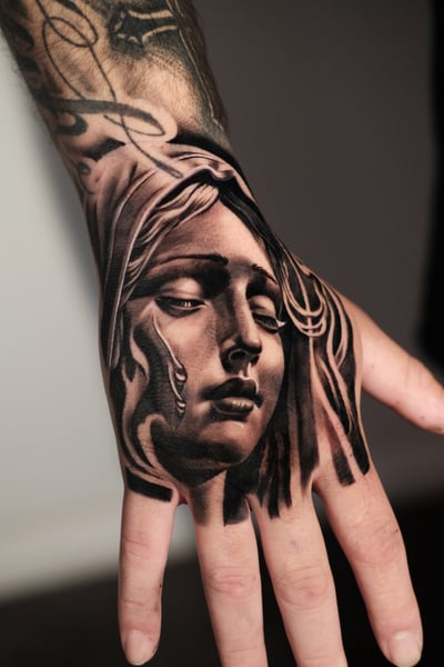 A black and grey realism portrait of a woman's face on the hand, featuring detailed shading and soft contours — by Johnny Ayala, los angeles