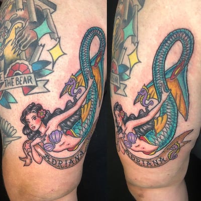 A colorful neo-traditional mermaid tattoo on the arm, featuring a sea serpent and a banner with bold illustrative style — by Sandra Price, los angeles