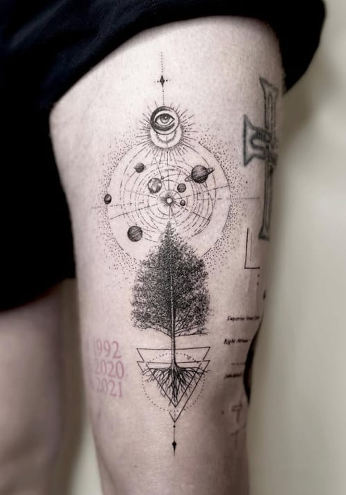 A black and grey geometric and dotwork tattoo on the thigh, featuring a tree with roots, celestial elements, and an eye above — by Jian Liang, los angeles