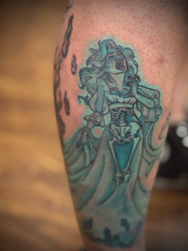 A colorful neo-traditional tattoo of a screaming ghostly figure with skeletal elements on the calf — by Sandra Price, ventura, ca