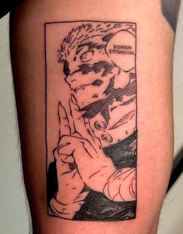 A black and grey anime-style tattoo on the leg, featuring a character with a speech bubble saying 'Domain Expansion' — by NJ TATTOOZ, corona, ca