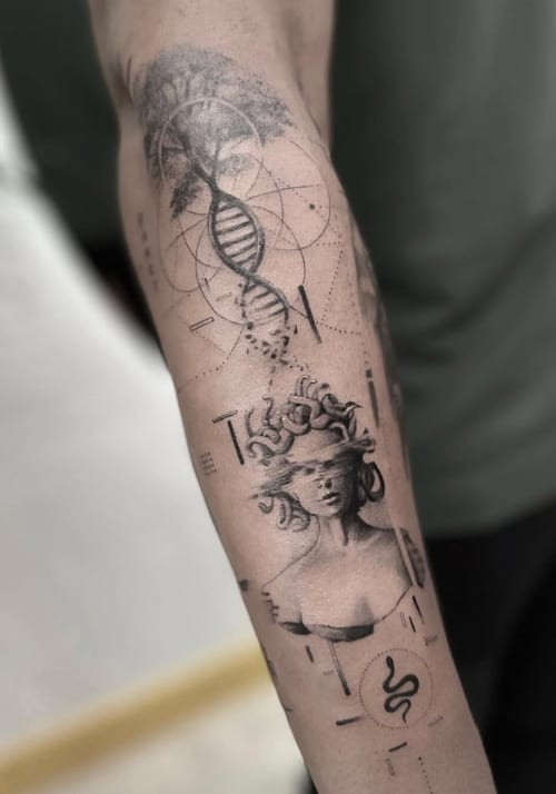 A black and grey tattoo on the forearm featuring a surreal depiction of Medusa with dotwork and geometric elements, including a DNA helix and snakes — by Jian Liang, los angeles