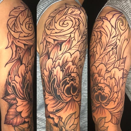 A bold black and grey floral design on the upper arm with intricate linework and shading in a Japanese style — by Sandra Price, los angeles