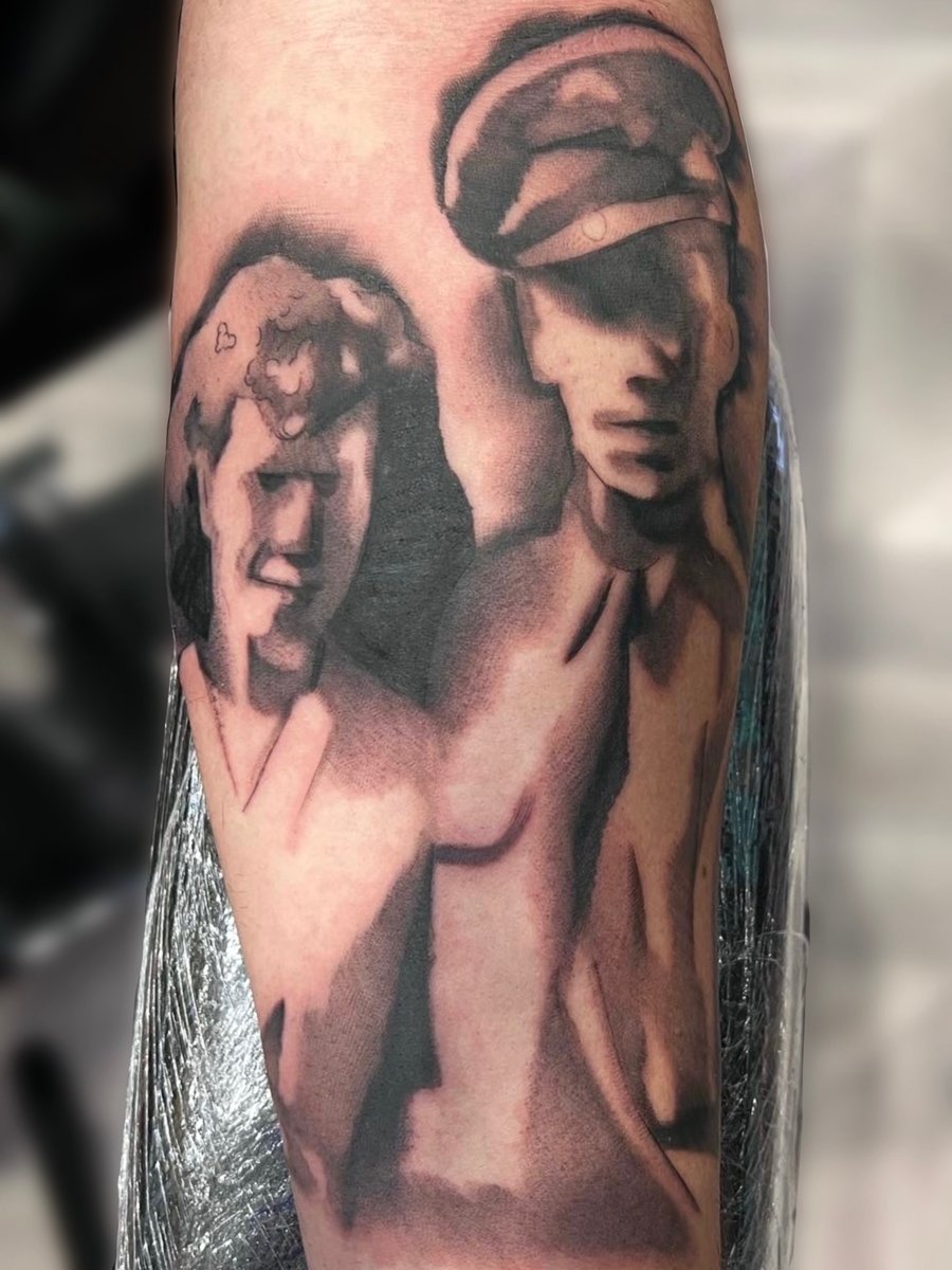 A black and grey portrait tattoo on the forearm depicting two people in a vintage style, possibly a memorial piece — by Josue Bravo, los angeles