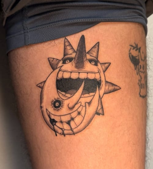 A black and grey illustrative tattoo on the thigh depicting a surreal sun and moon with exaggerated facial features and expressions — by NJ TATTOOZ, los angeles