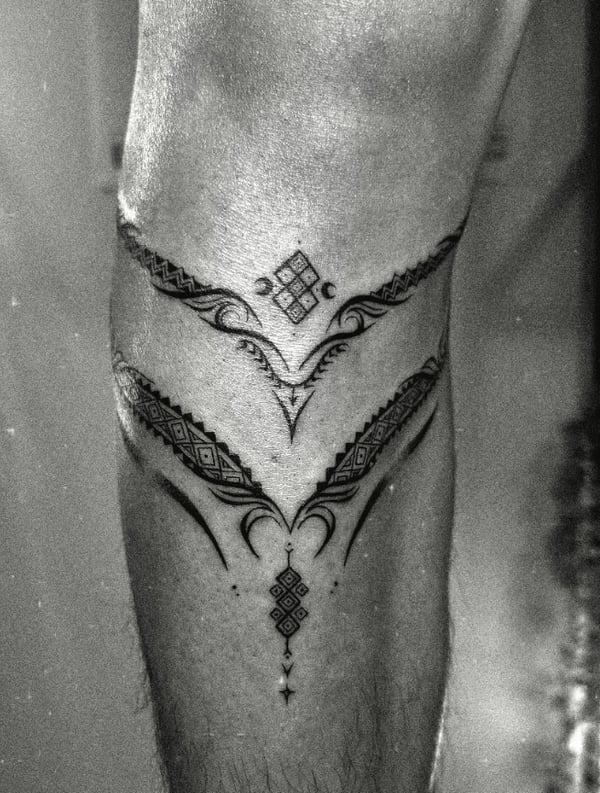 An ornamental blackwork tattoo on the leg featuring intricate geometric patterns and symmetrical designs — by NJ TATTOOZ, corona, ca