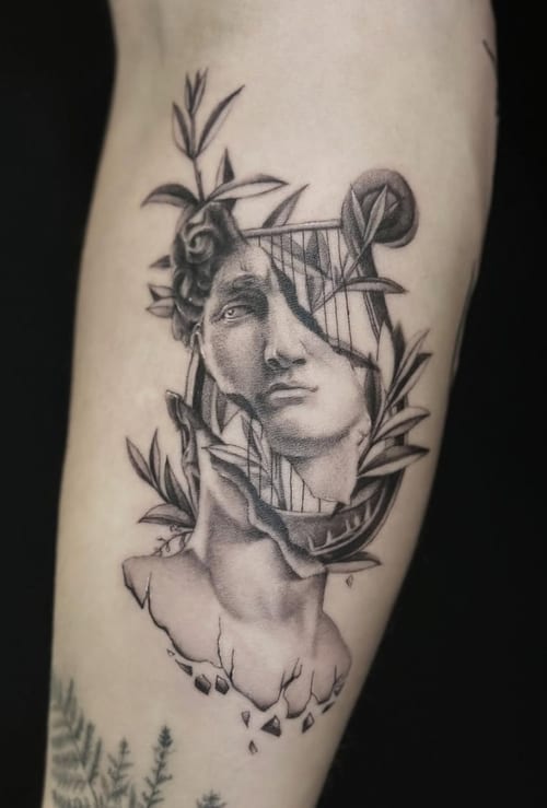 A black and grey surrealistic tattoo on the arm, featuring a fragmented face intertwined with floral elements and fine lines — by Jian Liang, los angeles