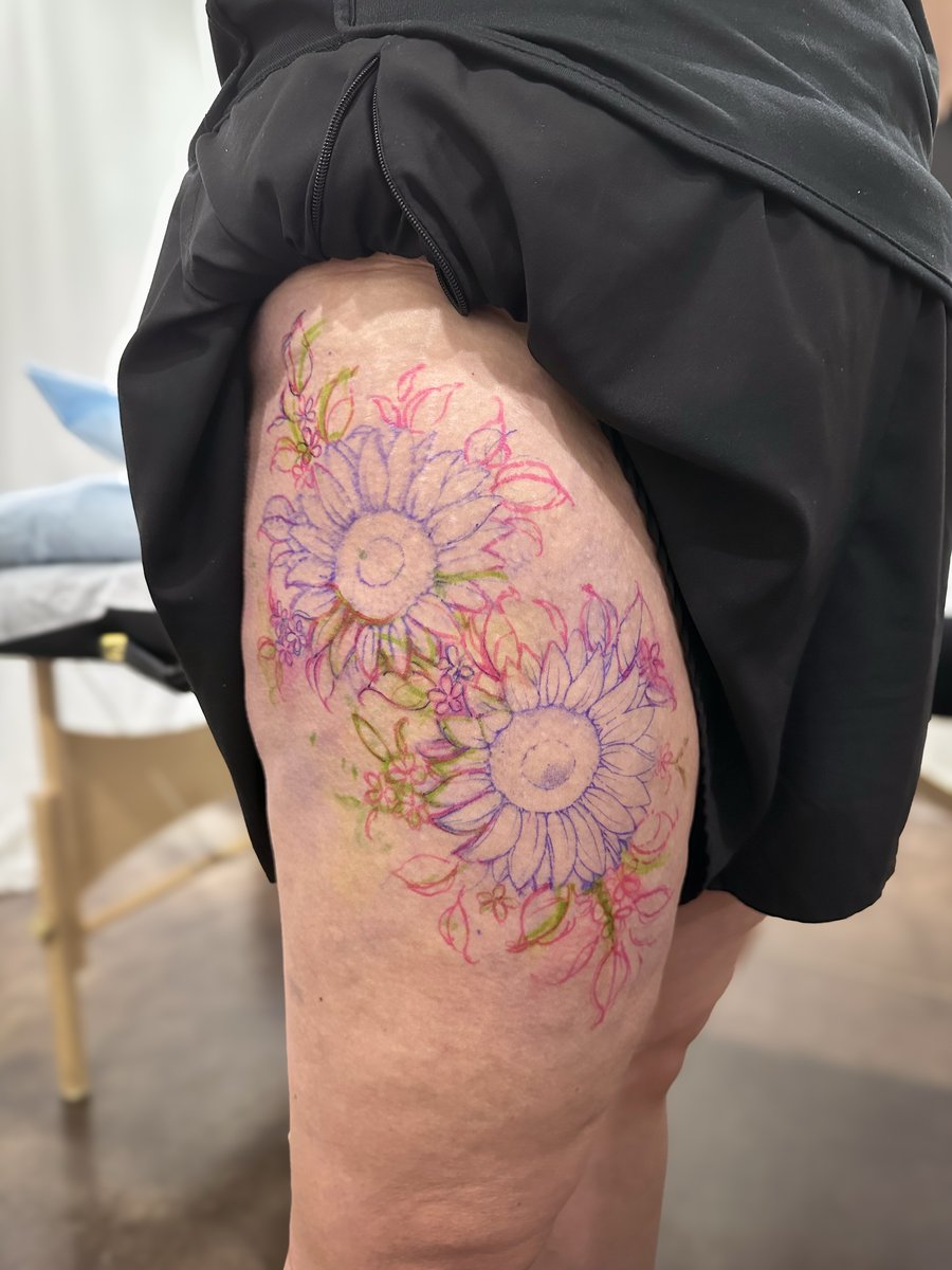 A colorful floral design featuring sunflowers on the thigh, with delicate linework and whimsical details — by Melanie Benoit, los angeles